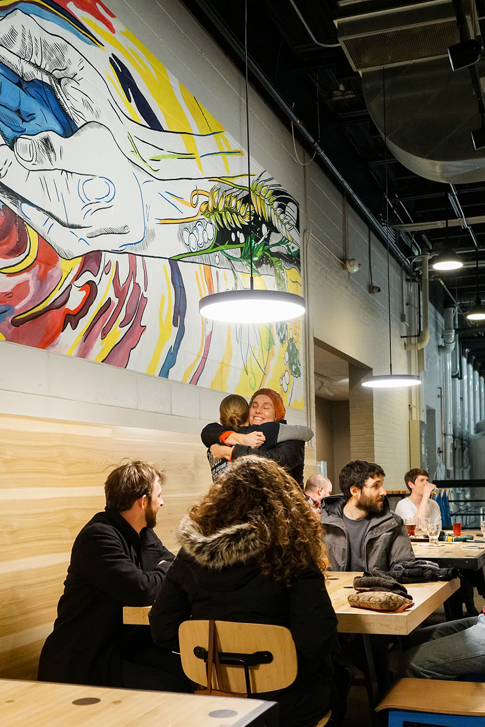 Friends Hugging in Front of Mural