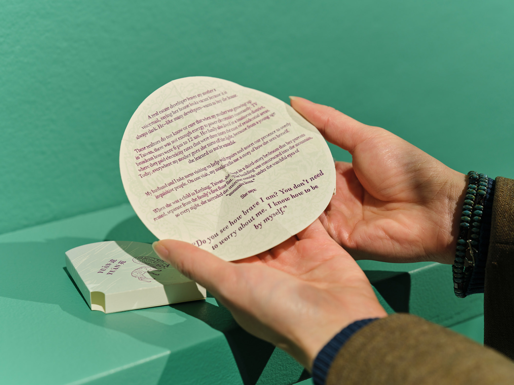 Gao holding artist's book, opening one page spread to a full circle