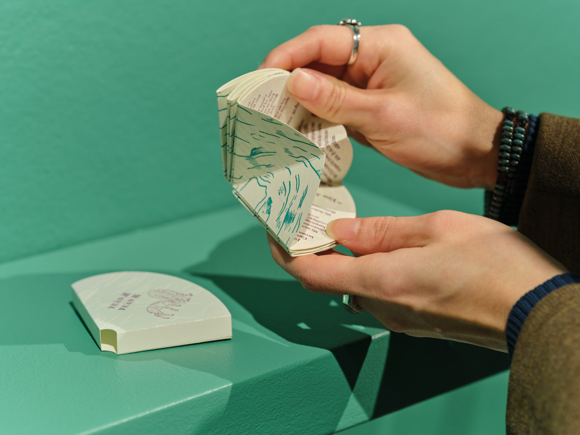 Gao holding artist's book, demonstrating how the book folds up